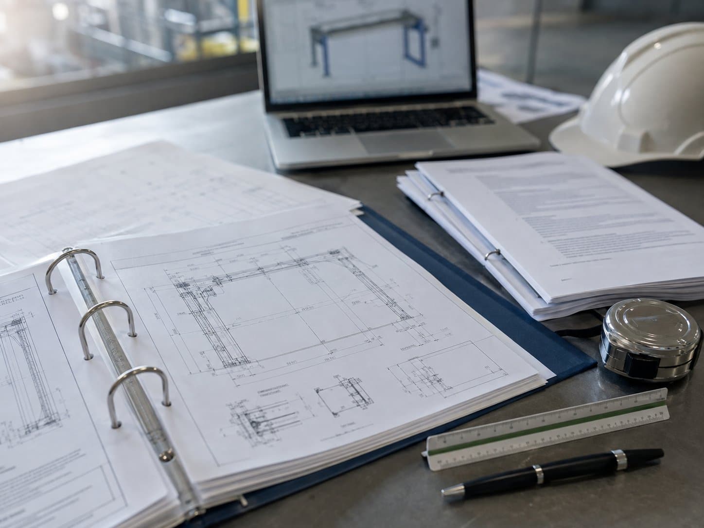Documentação técnica e projeto de engenharia da Force Movimentação, com desenhos, ART e equipamentos de medição sobre a mesa
